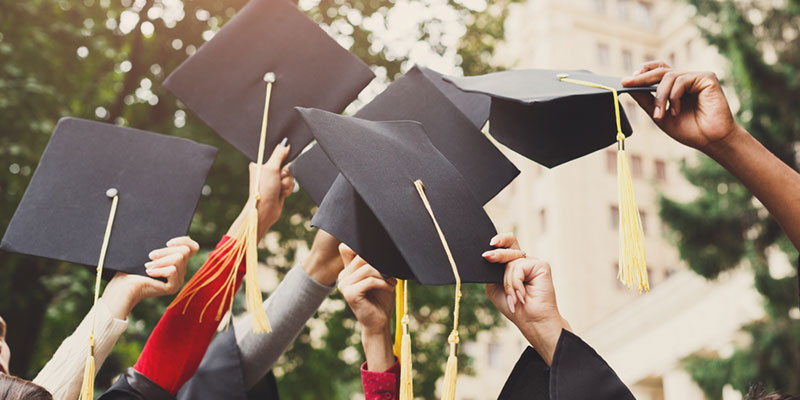 Six students holding graduation caps
