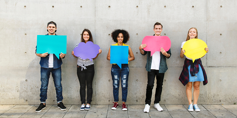 Five students holding cut outs of speech and thought bubbles