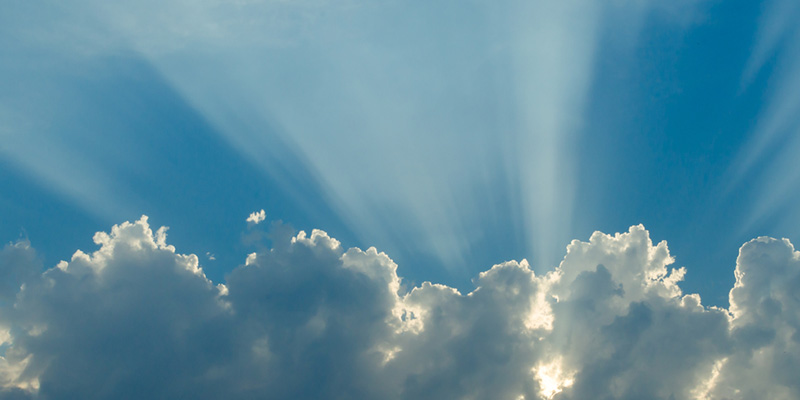 Blue sky and sun rays showing through clouds